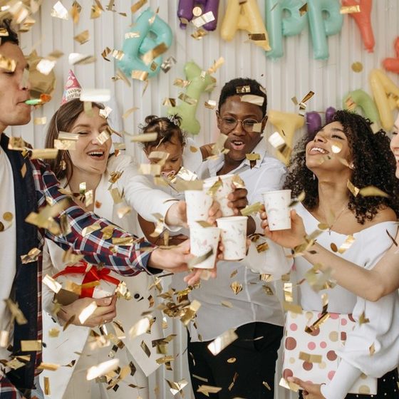 Friends celebrating in a shower of gold confetti