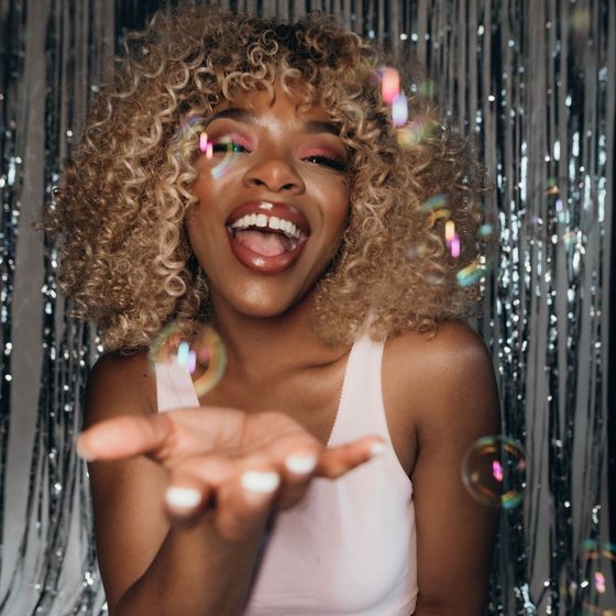 A guest blowing confetti at the camera